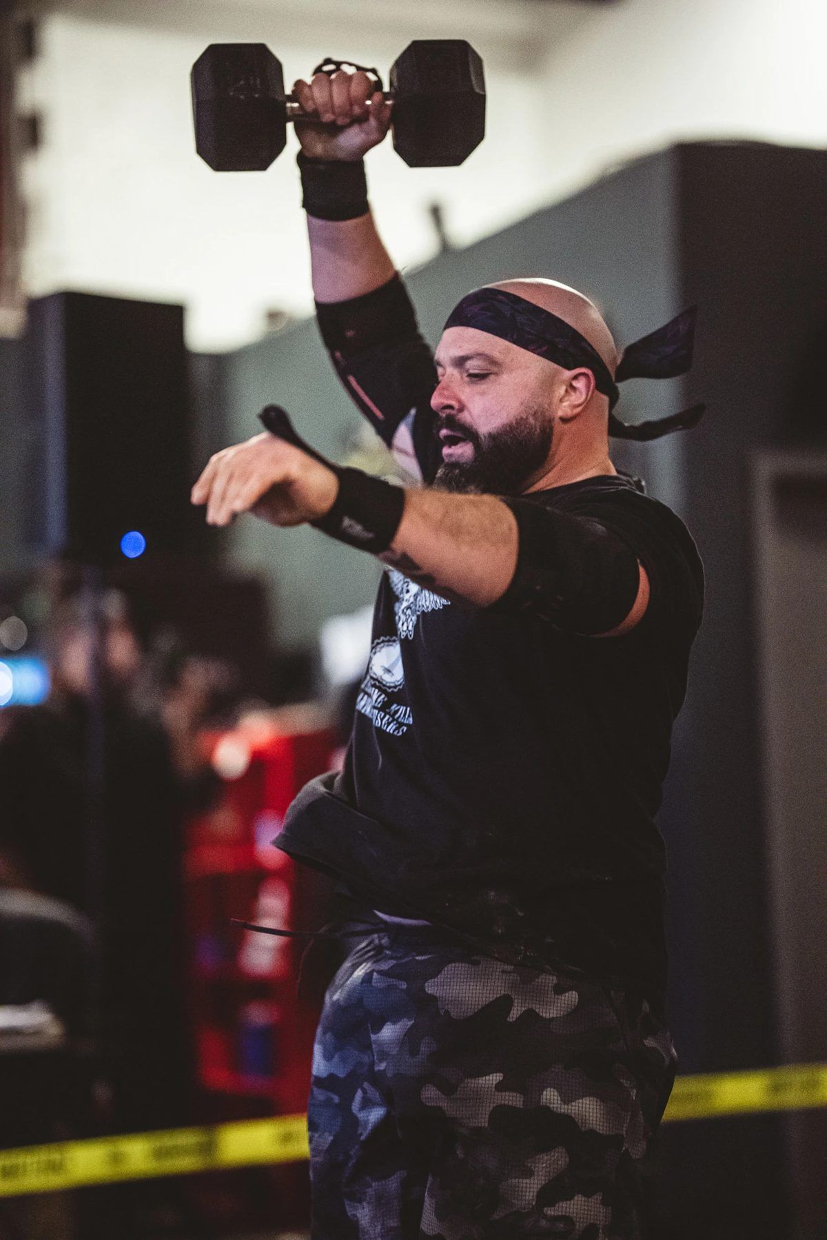Boston Iron Grit member pressing a dumbbell overhead in competition